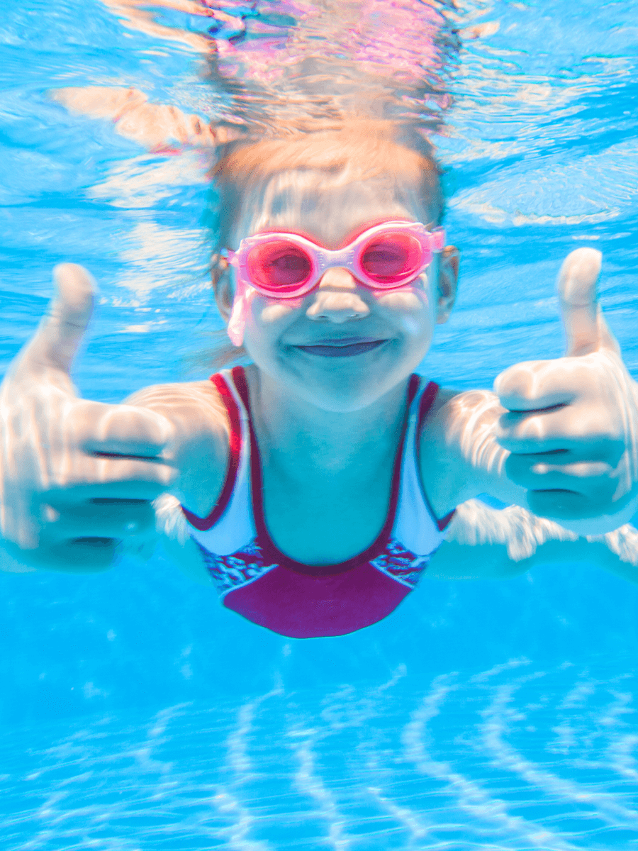 Girl underwater with thumbs up
